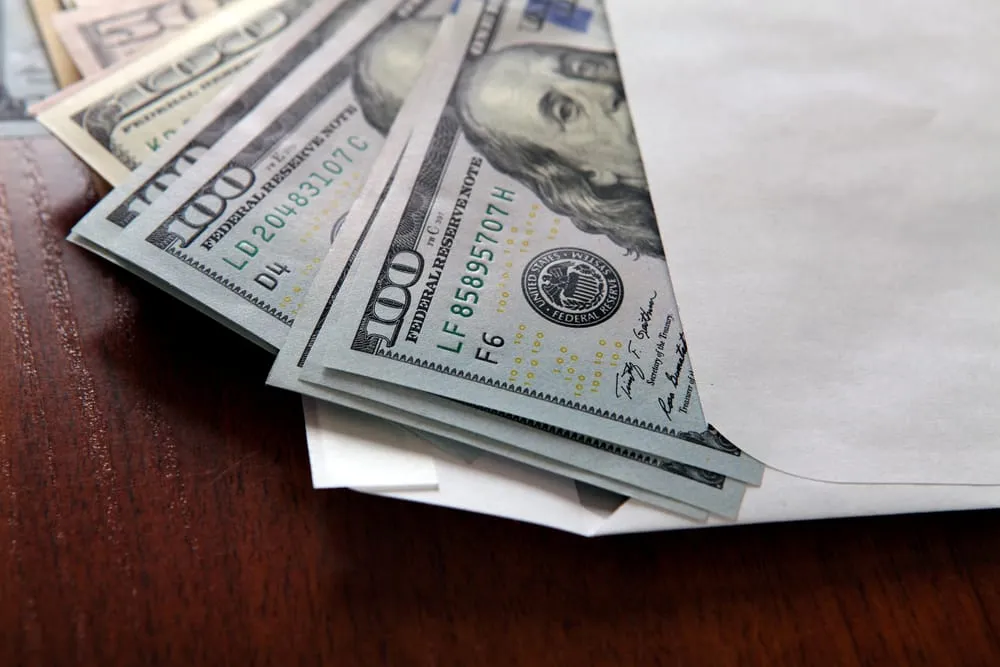 Liasse de billets de banque glissée dans une enveloppe